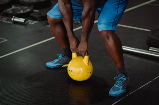 Man exercising with kettle-bell to build muscle at home