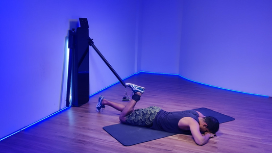 Person performing a seated hamstring curl exercise on a machine in a gym