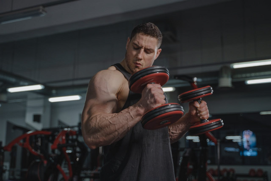 Man lifting dumbbells in a gym, showcasing bicep exercises for muscle growth.