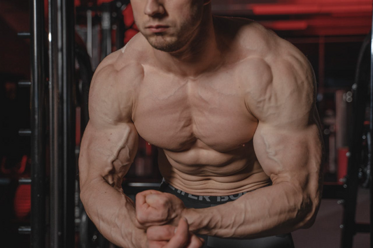 Man flexing his chest muscles in a gym, demonstrating chest growth exercises
