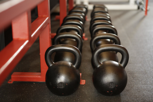 A row of kettlebells representing muscle mass training